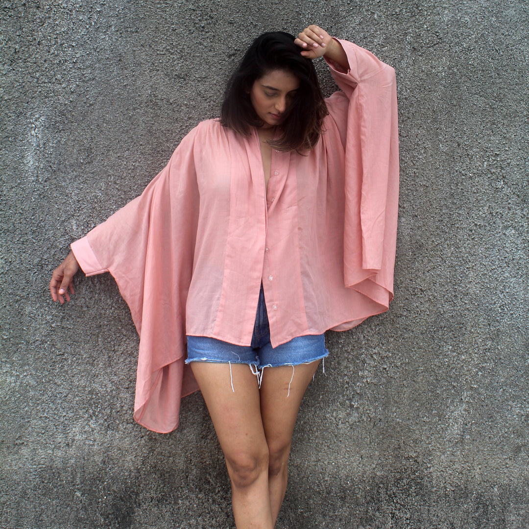 The shirt has kaftan-style sleeves with ruching on the front and back