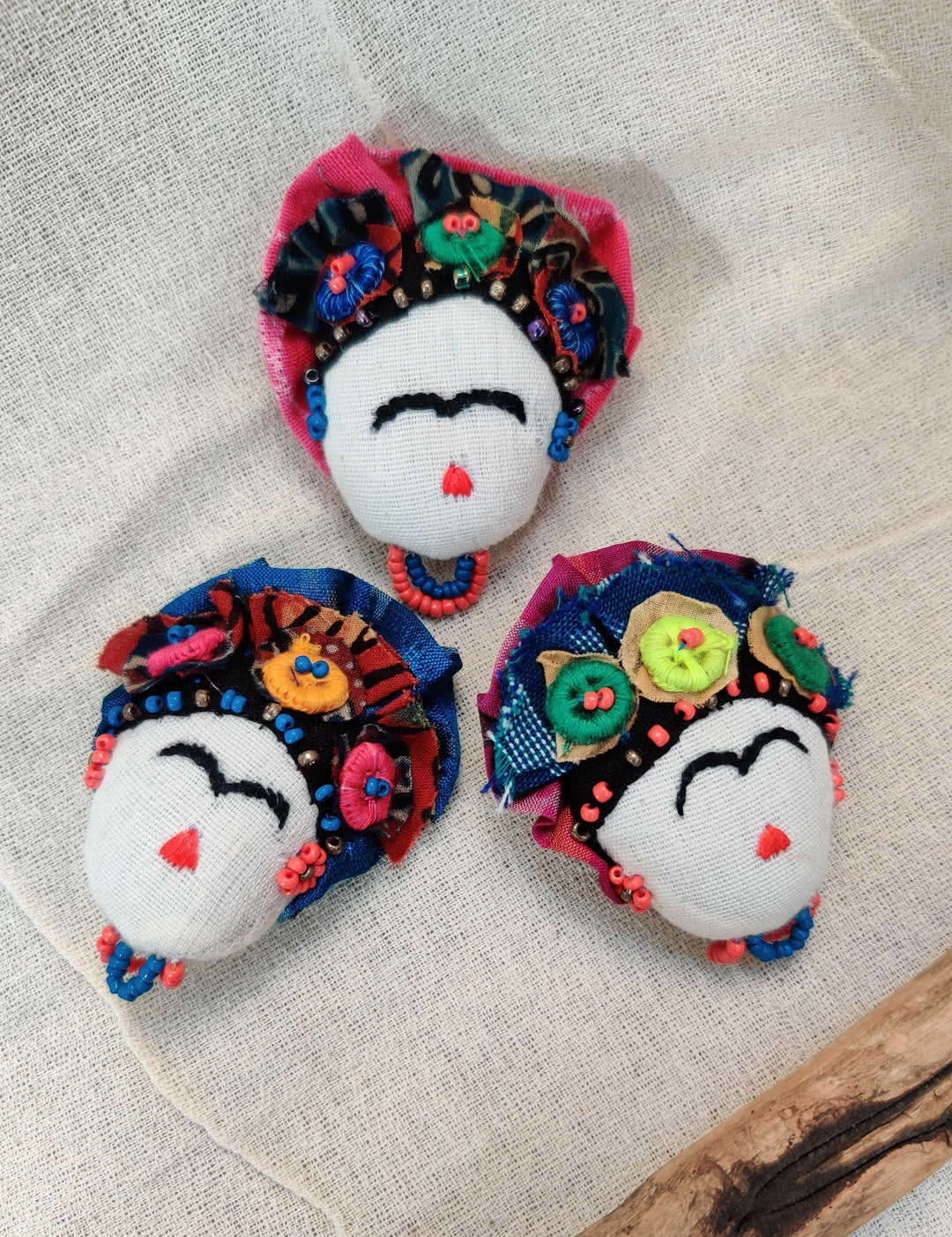 brooch with a white face pattern and crown with blue and pink detailing