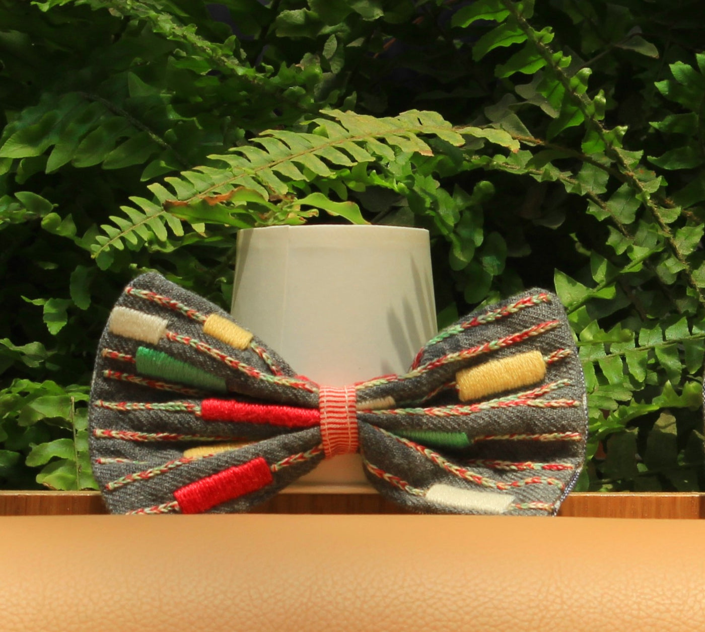 A slate grey handloomed bow tie made out of wool blend with intricate embroidery.