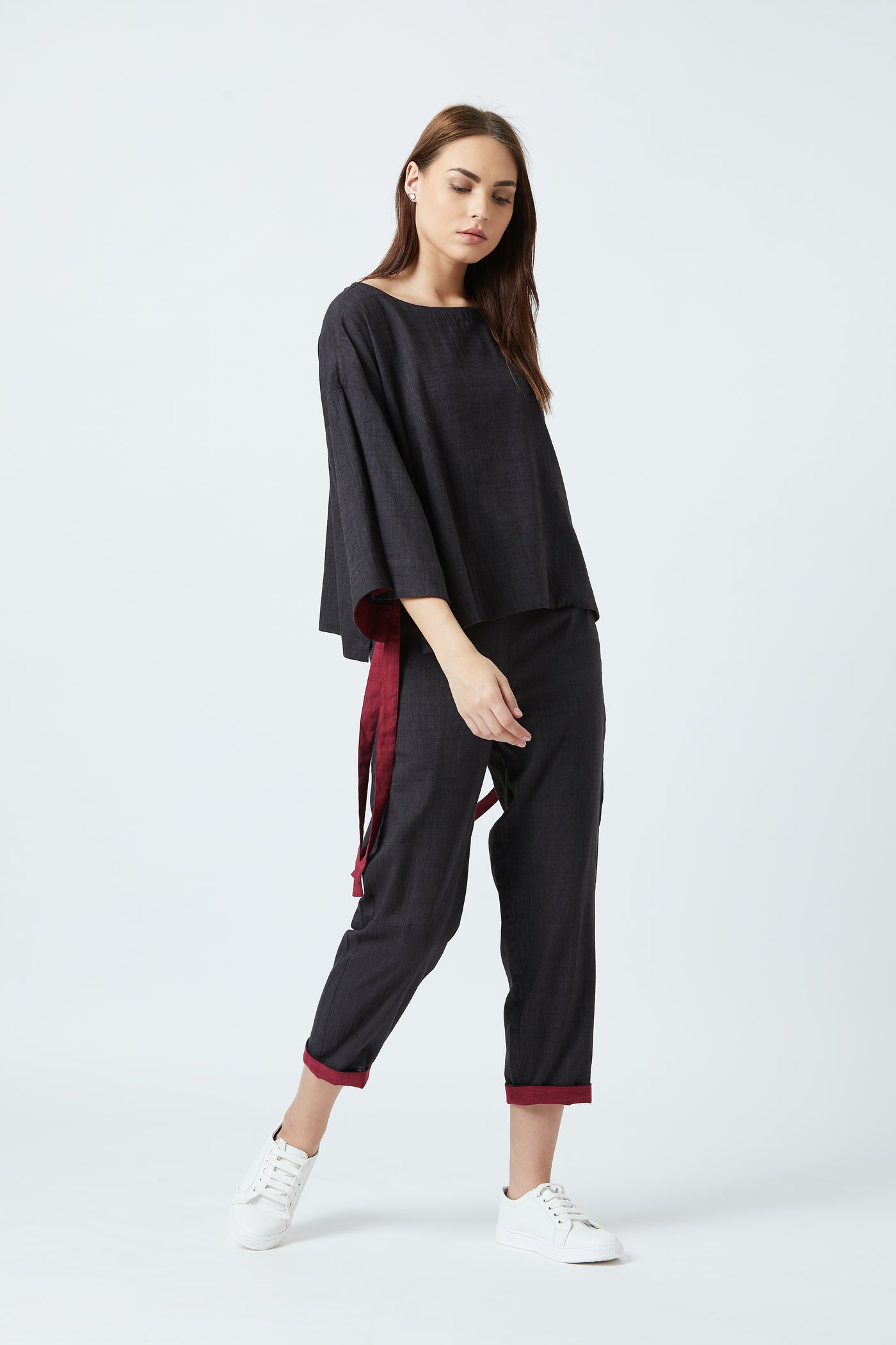 Loose fit black ankle pants with red detailing on the cuffs.