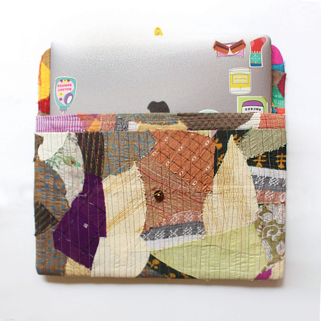 The scrap up laptop sleeve has been made using post production scraps. The laptop sleeve has front pockets