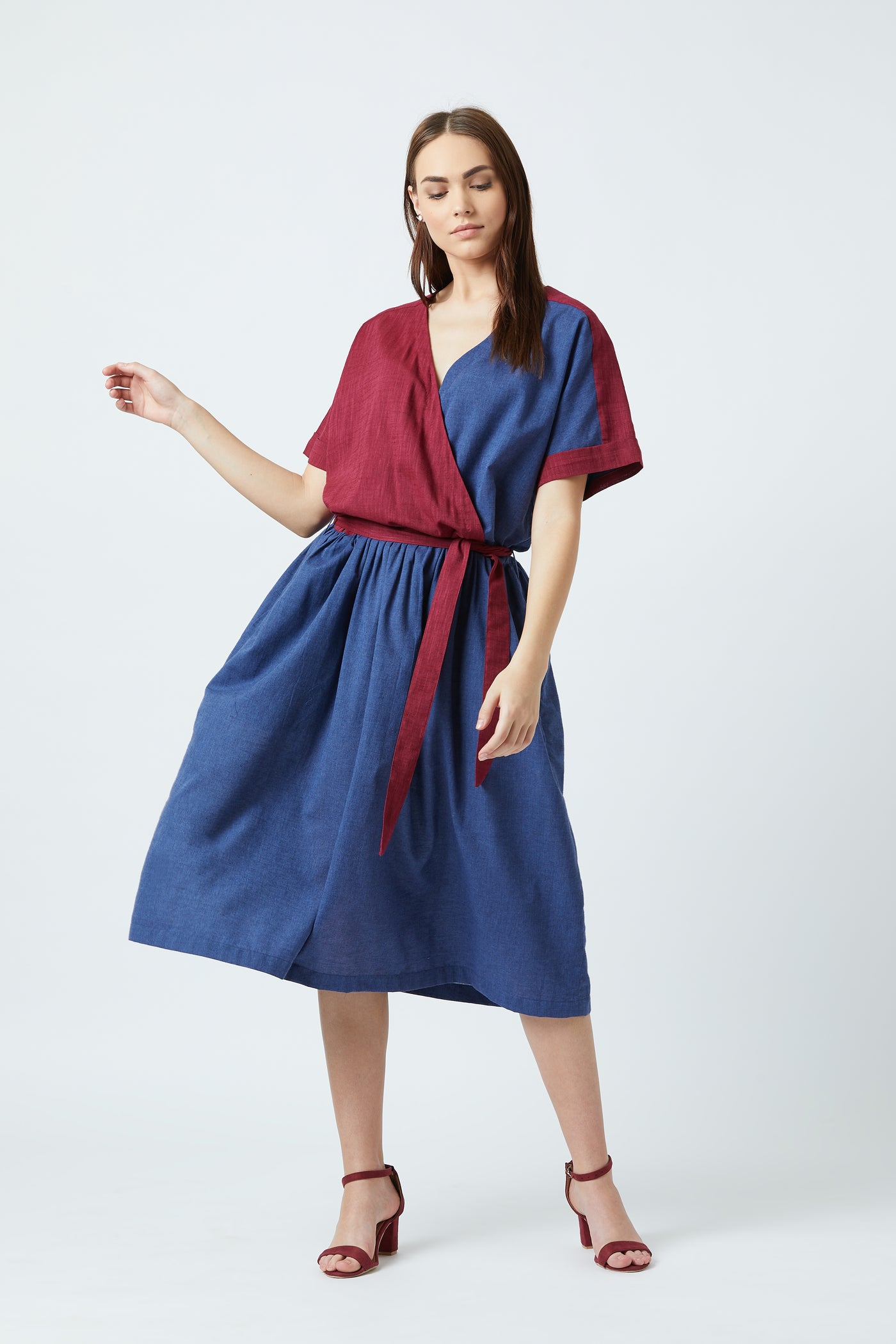 A blue oversized dress which is structured at the waist with a belt