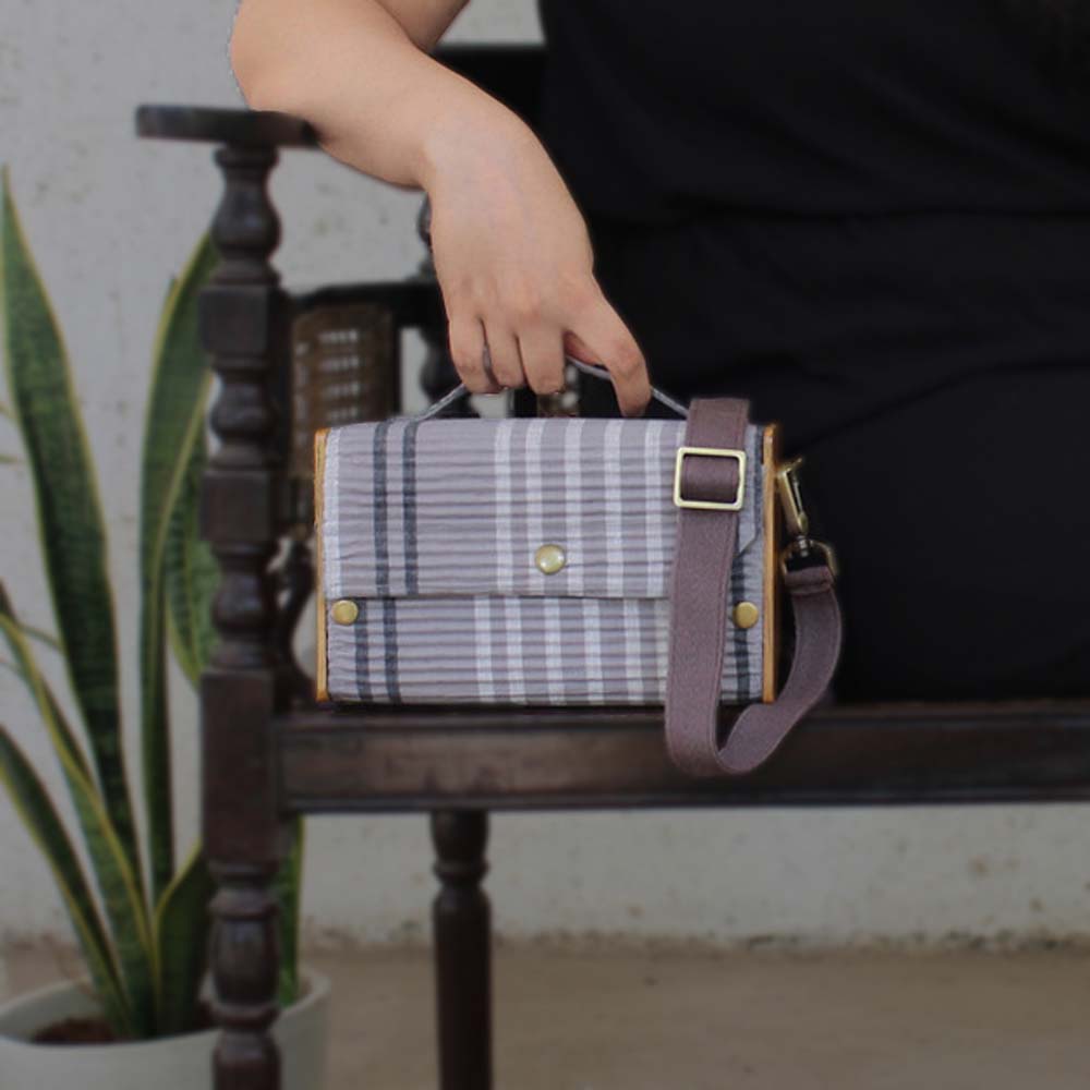100% handcrafted box clutch comes with a detachable sleeve featuring grey double lines.