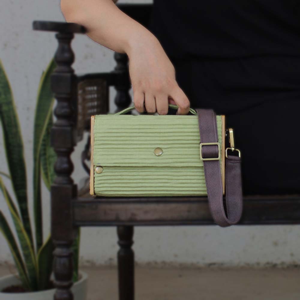 100% handcrafted box clutch comes with a detachable sleeve in a solid pista Green shade.