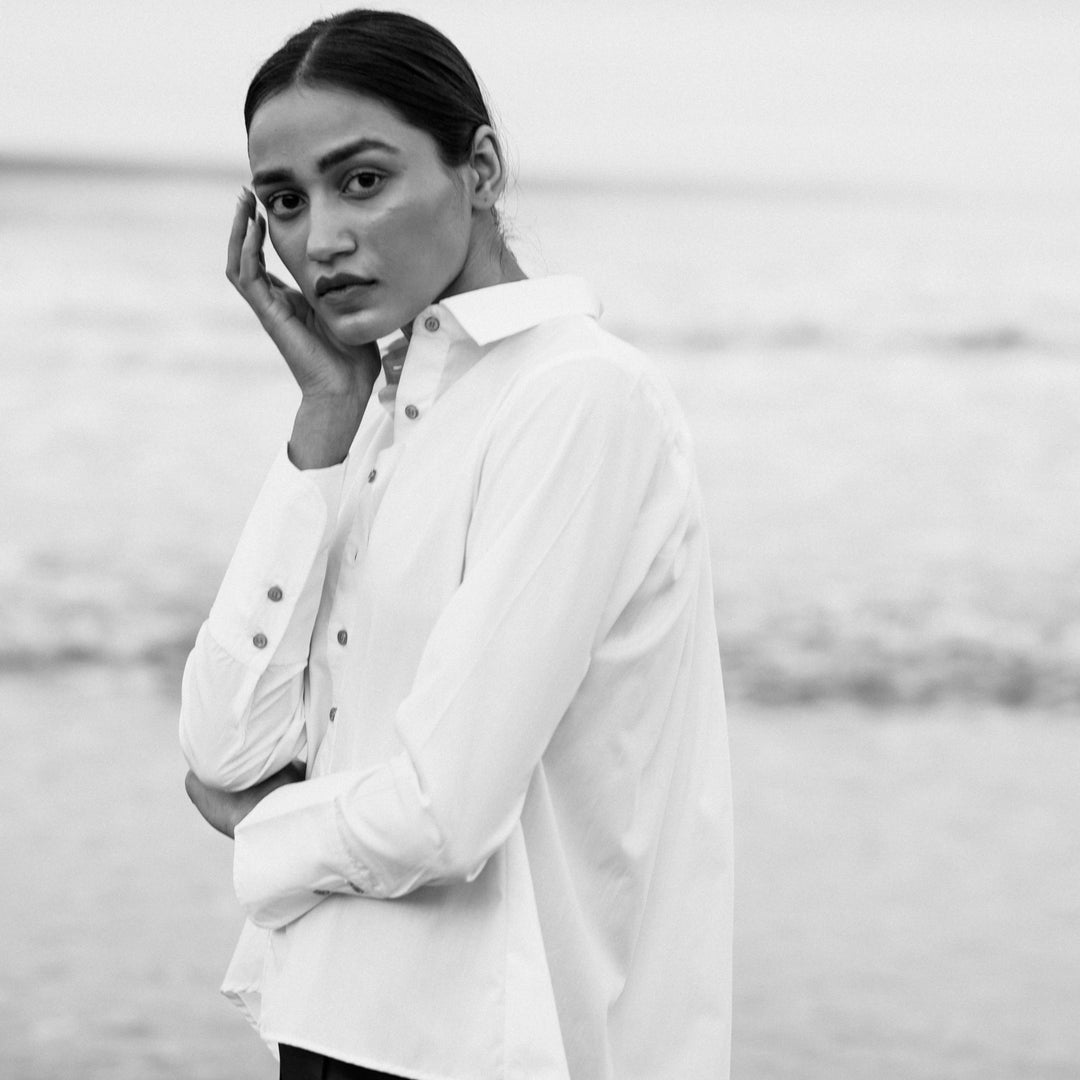 White poplin shirt with regular collar and buttons in front. The back is longer than the front.