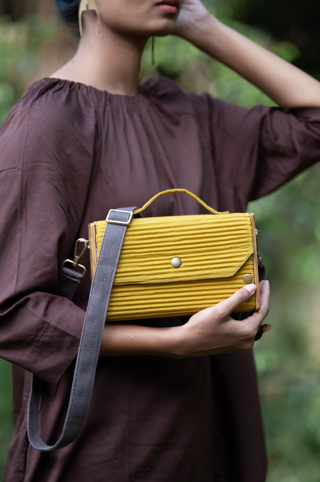 100% handcrafted box clutch comes with a detachable sleeve in a solid yellow shade.