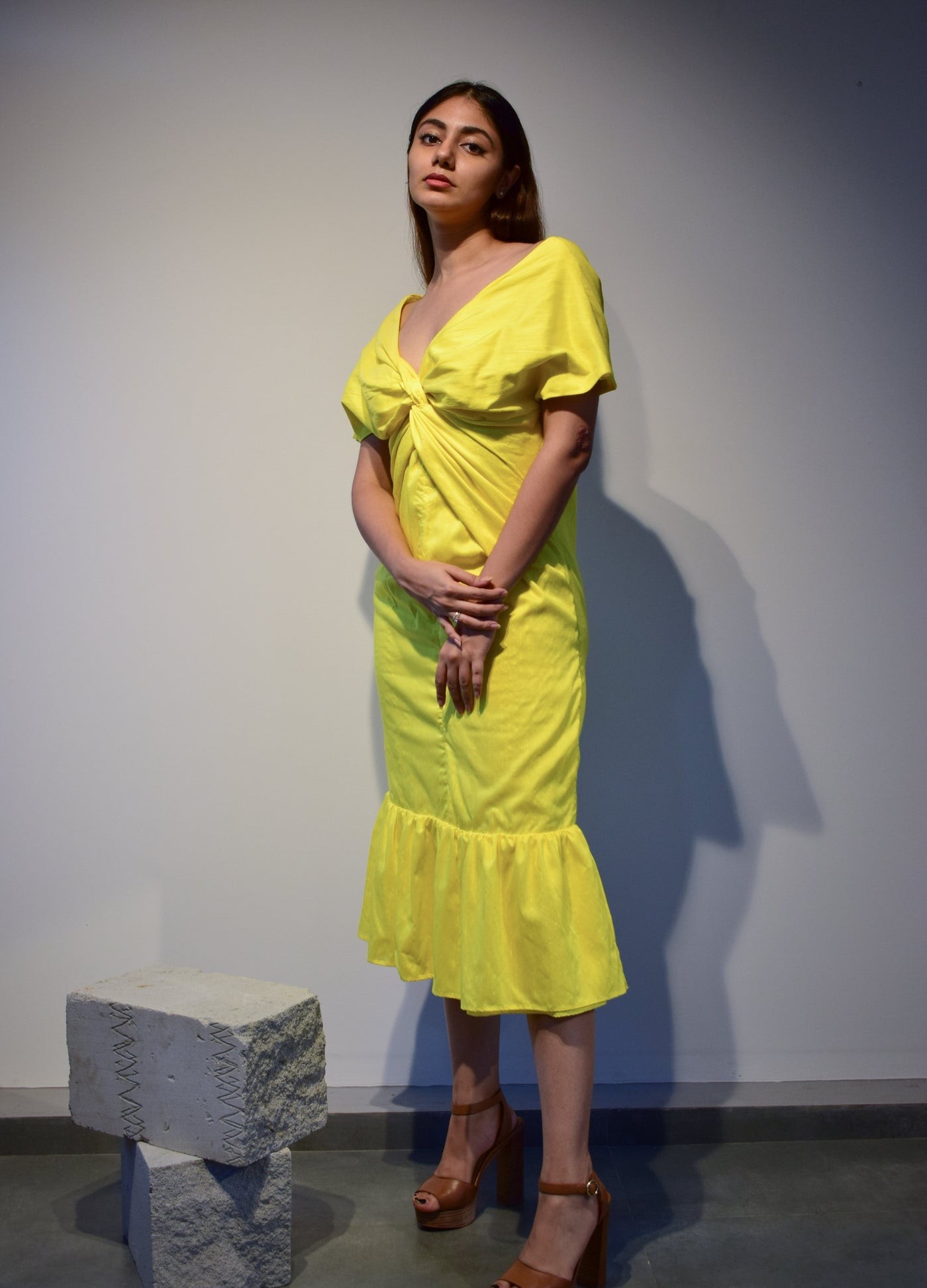 Bright yellow midi dress with a twist drape style at the empire line