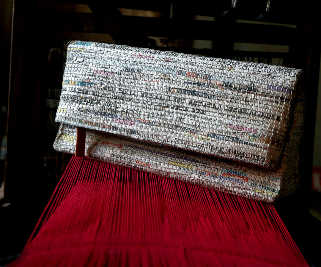 Handcrafted and handwoven navy clutch with newspaper strips and cotton, newsprint pattern