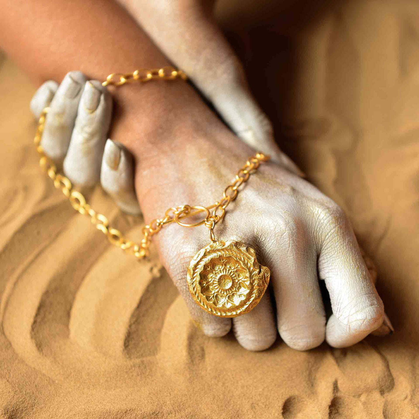 A dye gold necklace consisting of a chunky chain and a charm