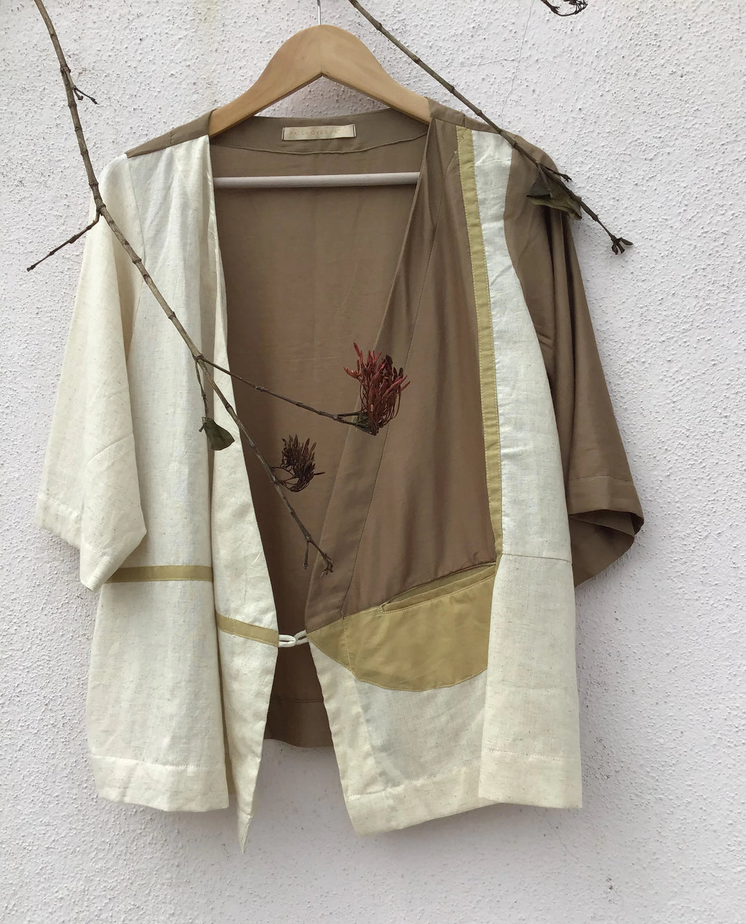 wrap top enriched with patchwork in the shades of off-white, beige and brown.