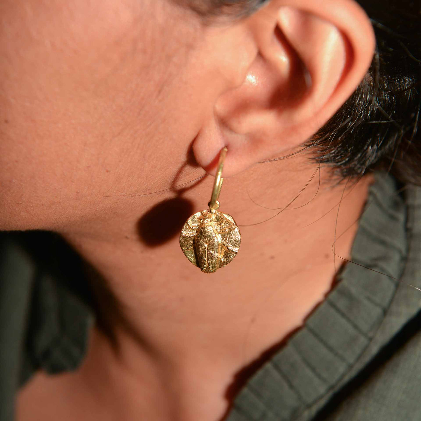 A pair of dye gold hoops, which are made to resemble fossils.