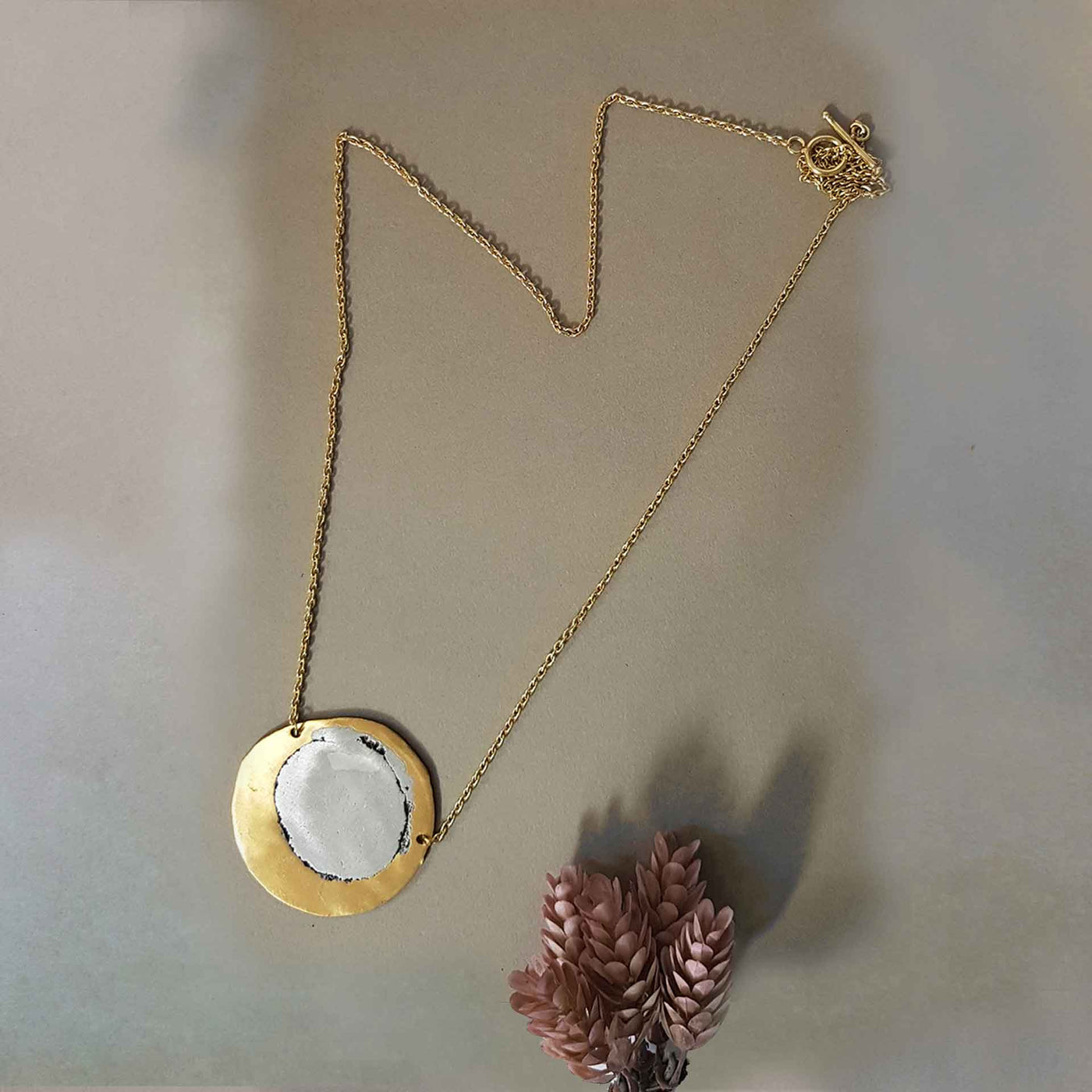 brass silver coloured necklace, with one circular charm