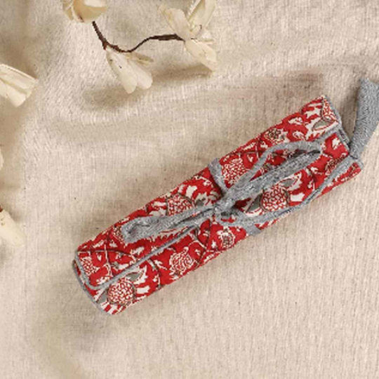 Red Kalamkari Print Roll-up Case tied using a grey cord which has a tassel attached to it.
