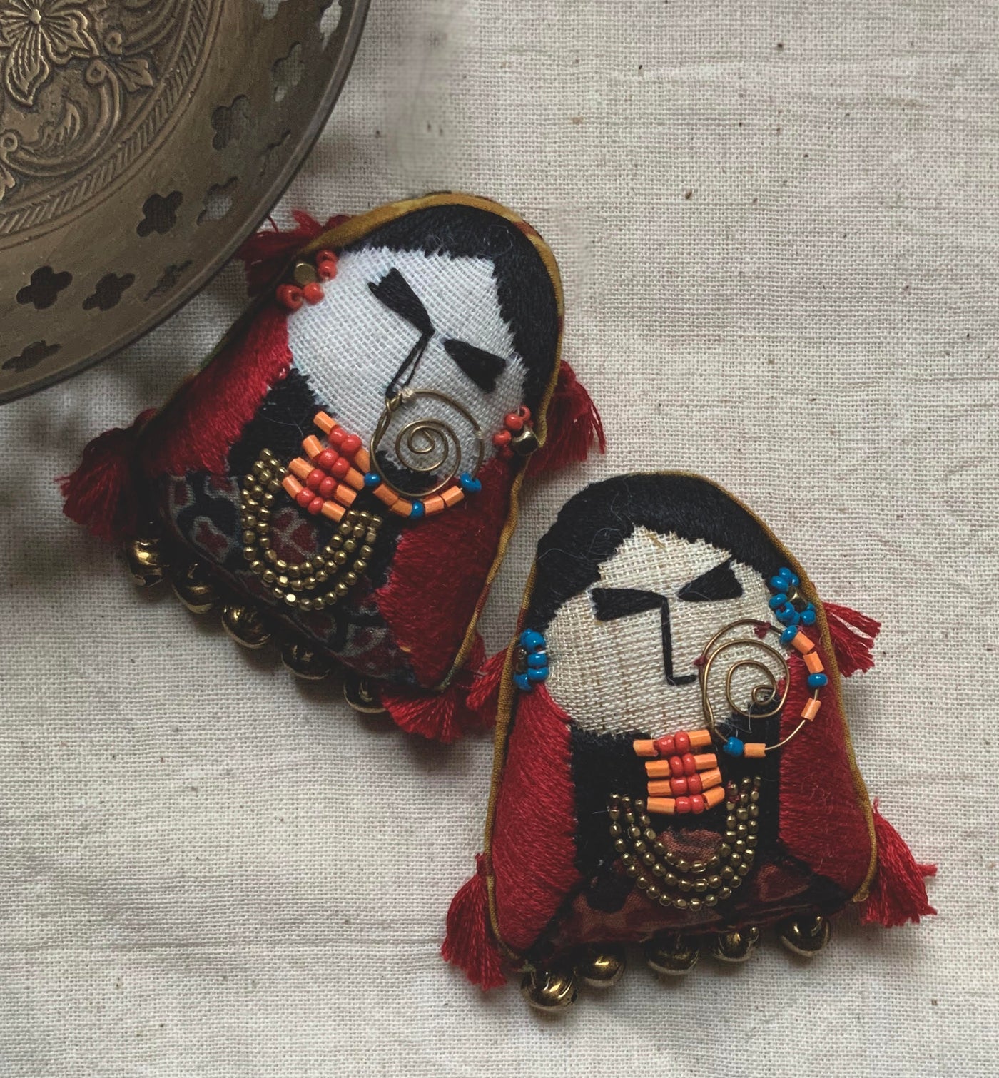 brooch pin with women's face and red detailing with jewelry