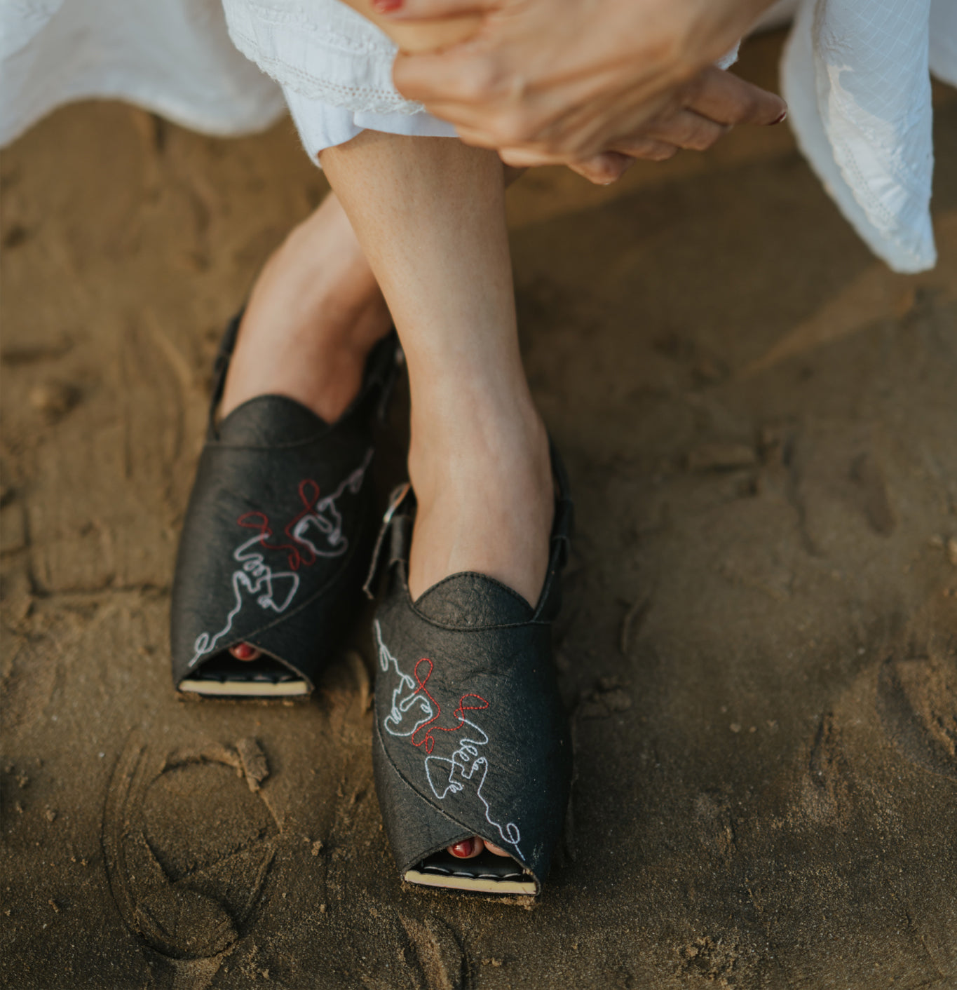 Black flats with backstrap and intricate line art embroidery