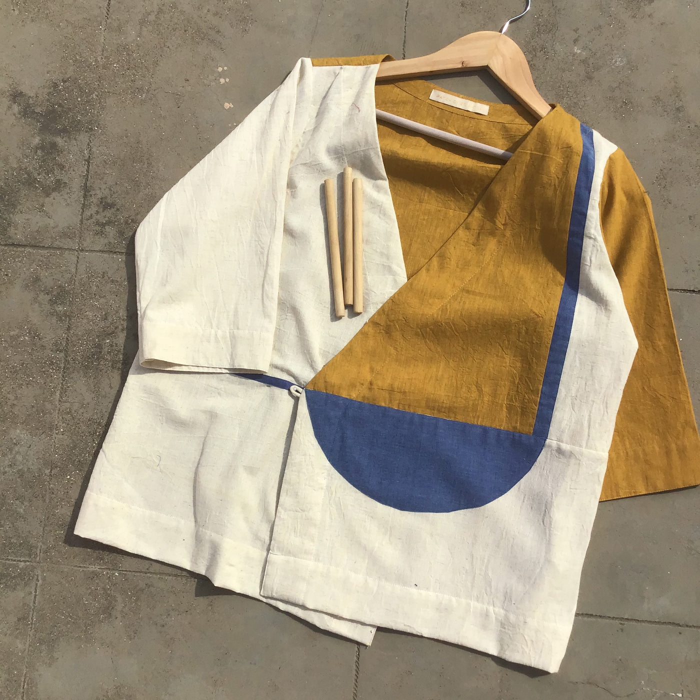 wrap top enriched with patchwork in the shades of off-white, mustard & blue.